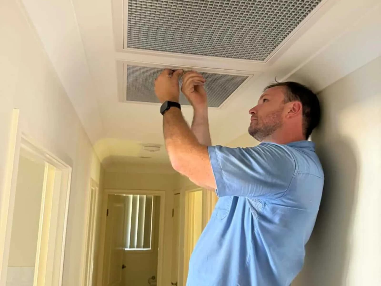 A Coola technician fitting a ceiling ducted vent in a Brisbane home